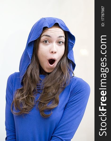 The happy young woman in brightly dark blue jacket is shocked surprise
