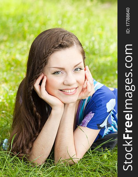 Attractive caucasian girl lying down on green grass. Attractive caucasian girl lying down on green grass