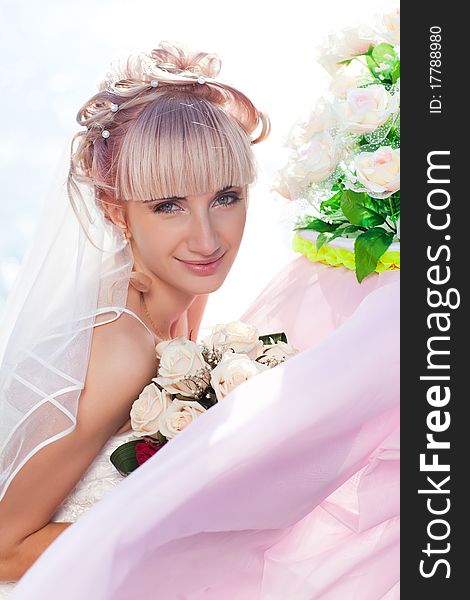 Pretty young bride posing to camera with flowers. Pretty young bride posing to camera with flowers