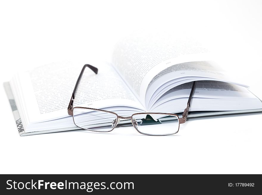 Glasses on an open book isolated on white