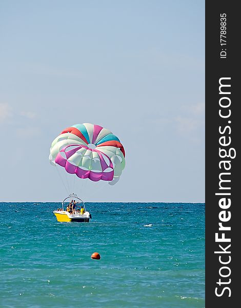 Motor boat with parachute for parasailing on background of sky and horizon.