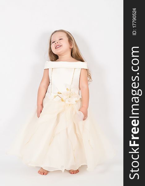 A beautiful little girl in a white dress in the studio