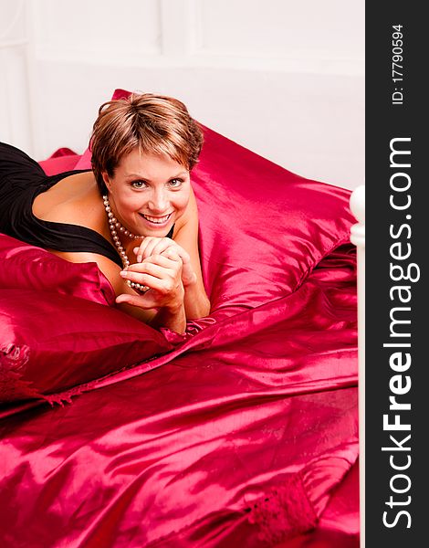 Charming  Woman In A Black Dress On A Bed