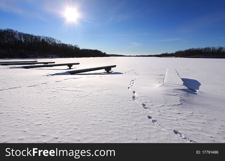 Empty dock in frozen lake in the winter time. Empty dock in frozen lake in the winter time