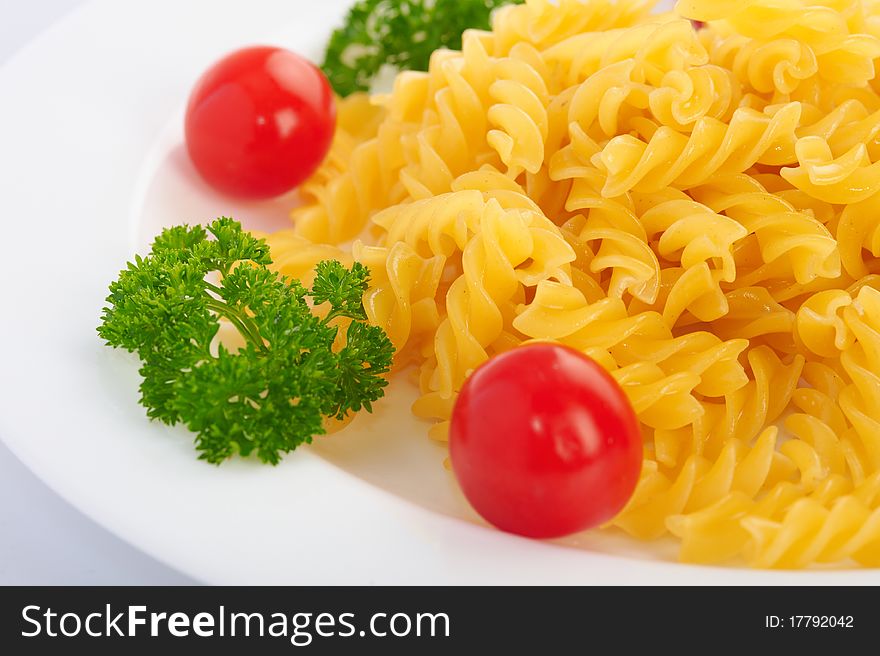 Pasta on the white plate with cherry