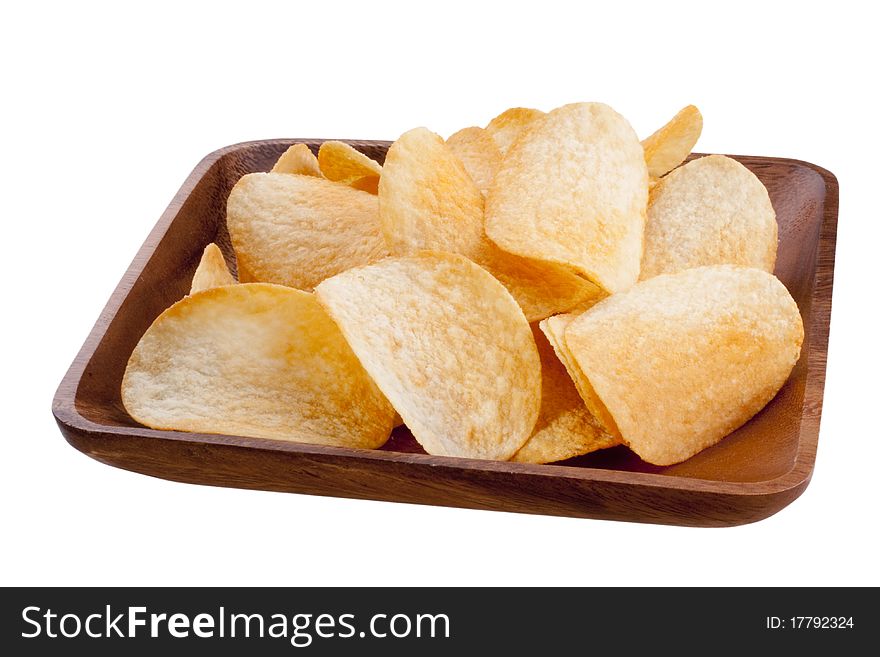 Potato chips from organic products in a wooden plate.