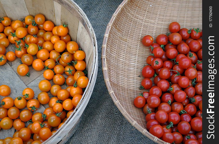 Two baskets of fresh cherry tomatoes at market stand. Two baskets of fresh cherry tomatoes at market stand