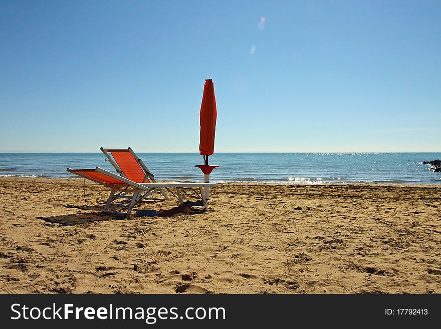 Sunshade and sun-lounger on the beach