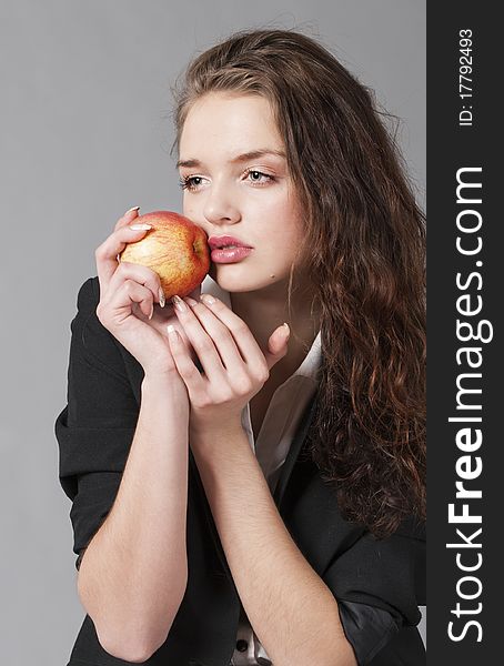 Portrait of the young girl in strict clothes with a red apple