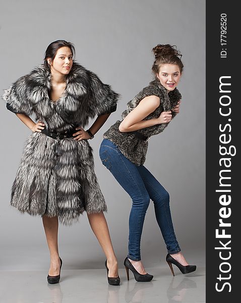 Two young girls show fur products. Two young girls show fur products