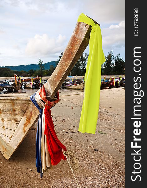 Colourful flags tied around the bow of a longtail boat moored on the beach. Colourful flags tied around the bow of a longtail boat moored on the beach