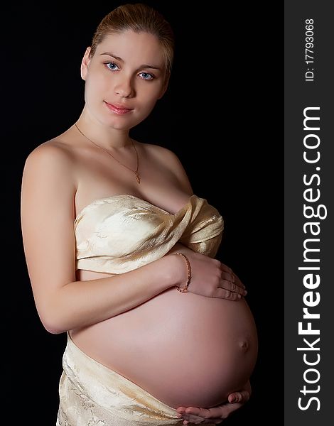 Portrait of a beautiful pregnant woman on a black background