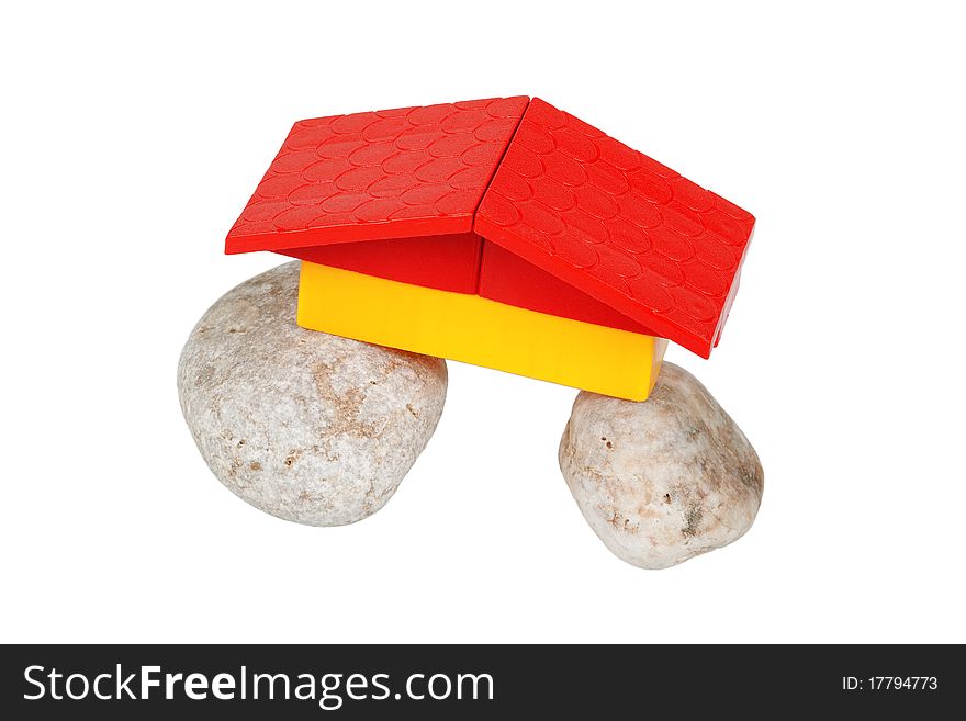 A conceptual model of a house, composed of stones and toy roof. A conceptual model of a house, composed of stones and toy roof