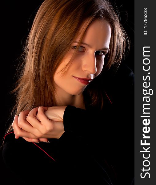 Happy young woman in black with her hands folded