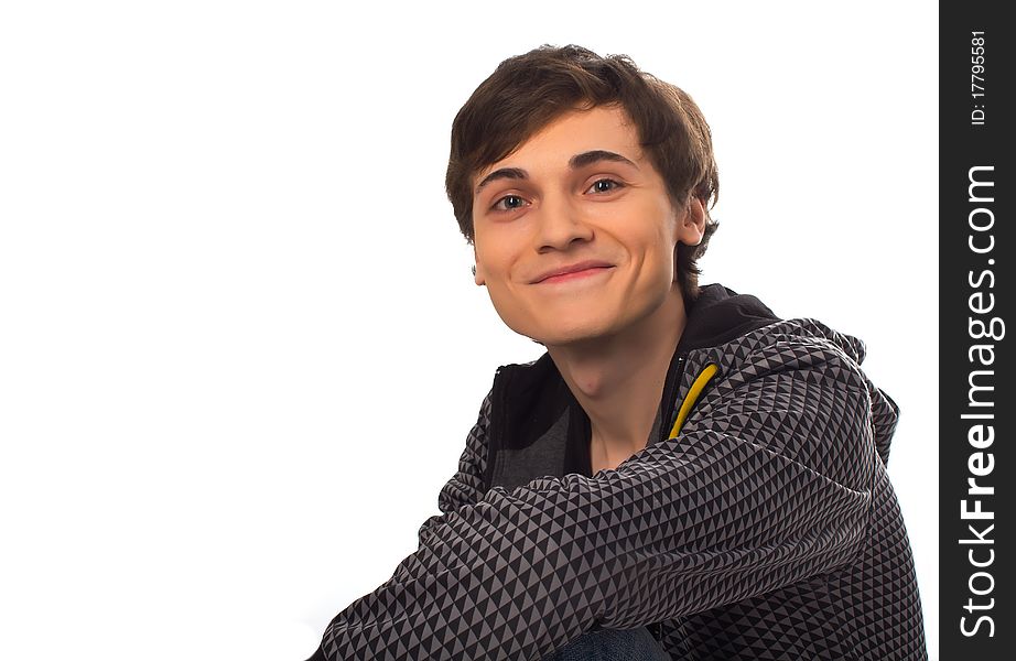 Happy young man sitting looking at camera and smiling on white background. Happy young man sitting looking at camera and smiling on white background