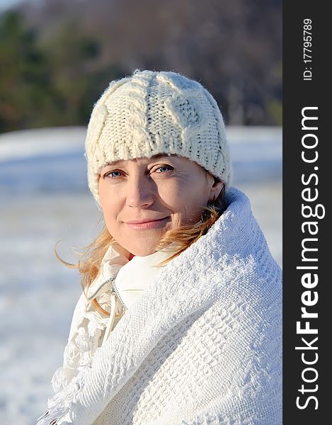 Adult woman in white on a snowy background, bright sunny frosty day