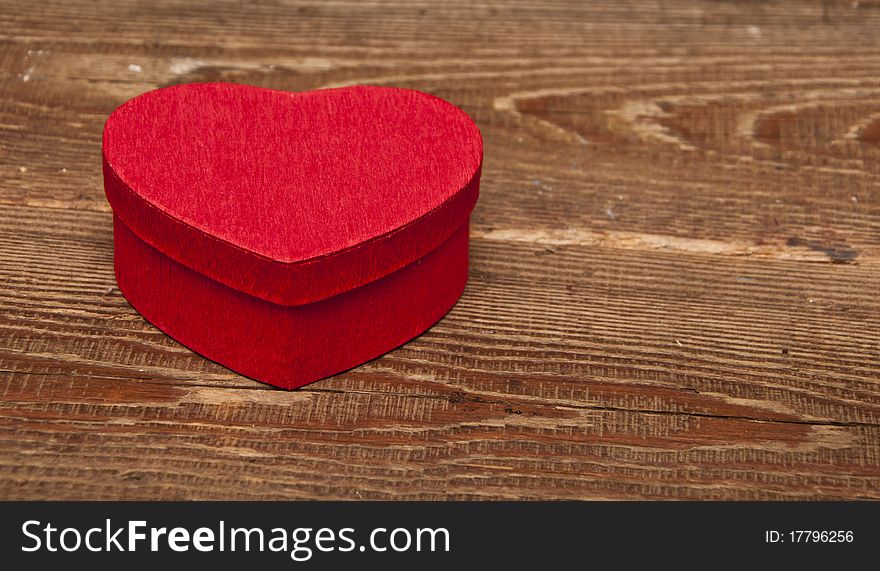 Red box in heart shape on wood background