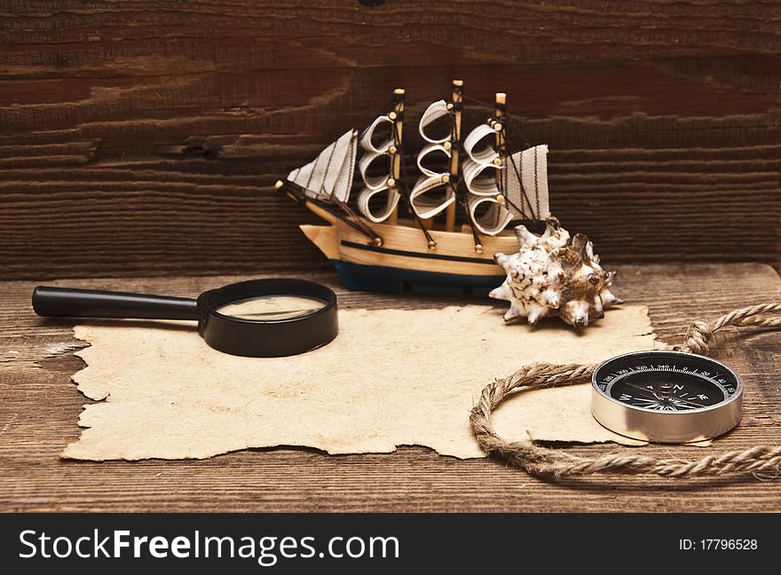 Old paper and model classic boat on wood background