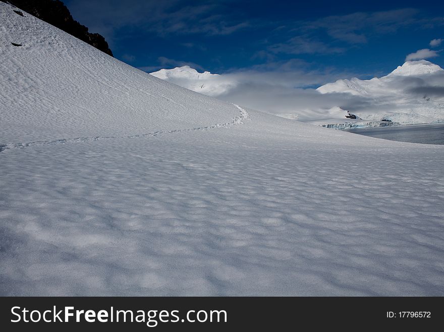 A trail leads through a snowy scene in Antarctica. A trail leads through a snowy scene in Antarctica