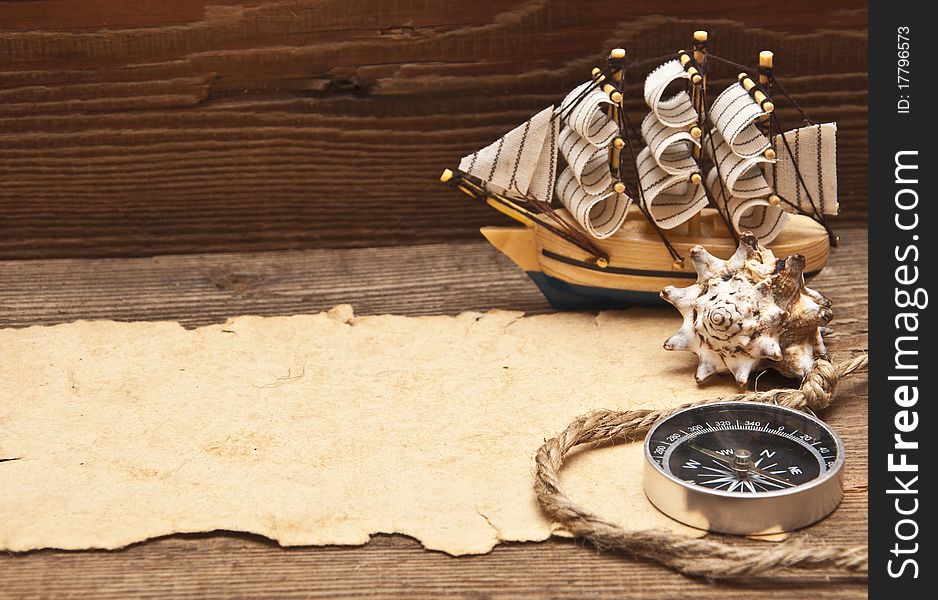 Old paper and model classic boat on wood background