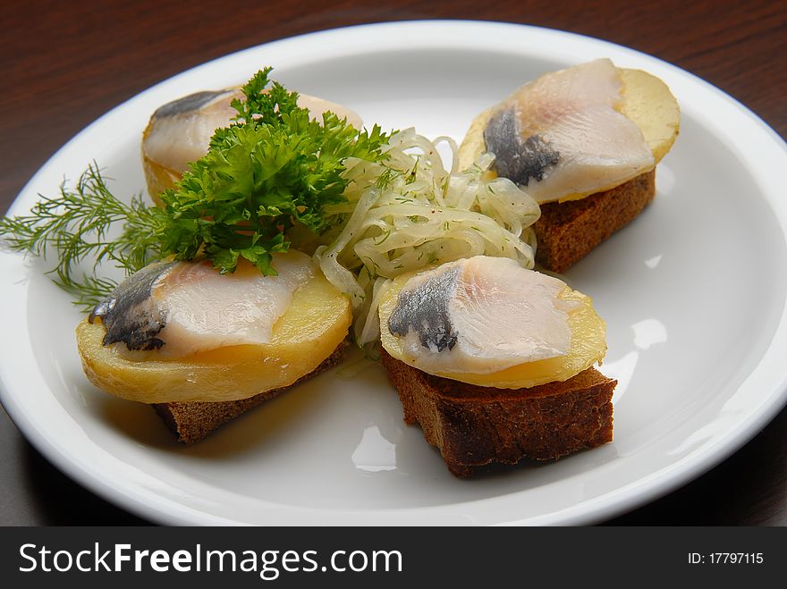 snacks with salt fish, potatoes and onions on bread. snacks with salt fish, potatoes and onions on bread