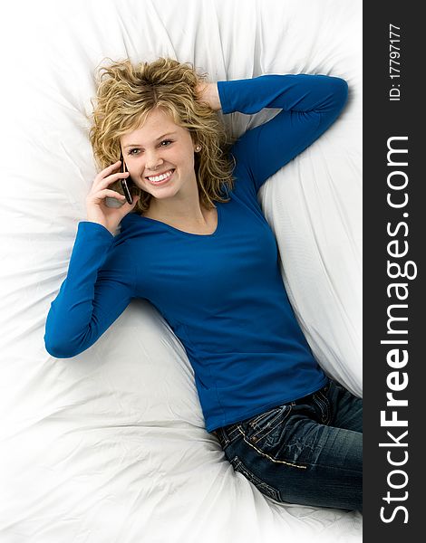 Attractive teenage girl lying down talking on phone. Attractive teenage girl lying down talking on phone