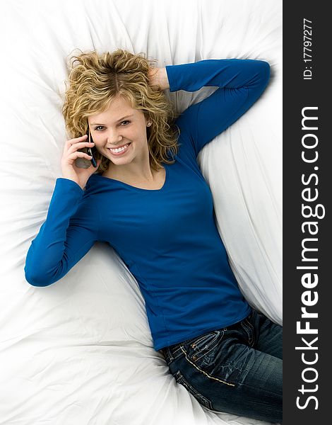 Beautiful teenage girl lying down talking on cell phone