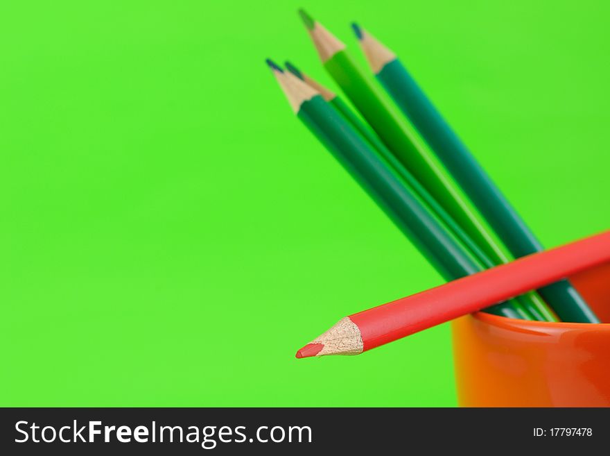 Colored Pencils In Cup on green background. Colored Pencils In Cup on green background
