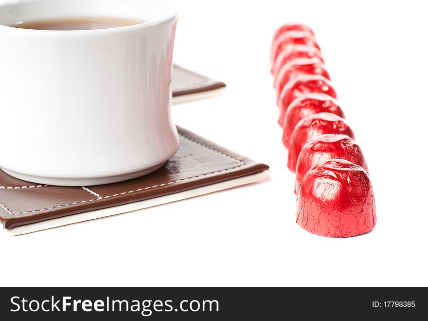 A cup of tea with sweets. Isolated on white background.