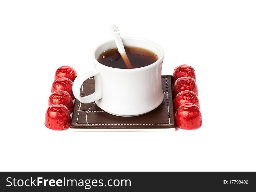 A cup of tea with sweets. Isolated on white background.