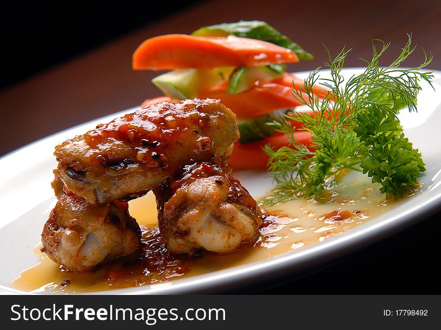 Chicken wings in sauce with fresh vegetables. Chicken wings in sauce with fresh vegetables