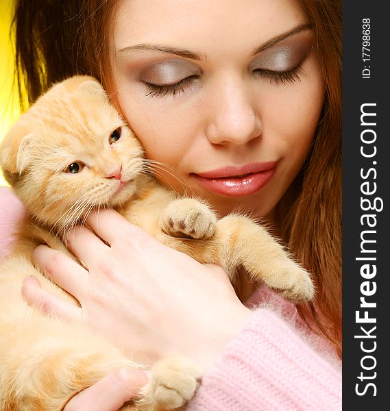 Young woman with red England lop-eared kitten