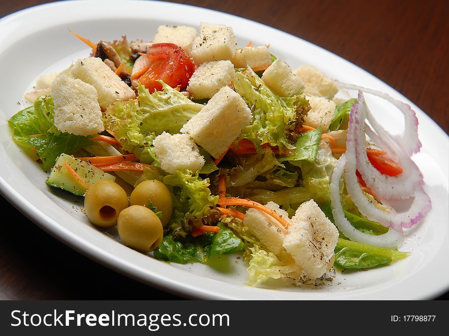 Salad with fresh vegetables and cheese, bread crumbs and onions on a plate