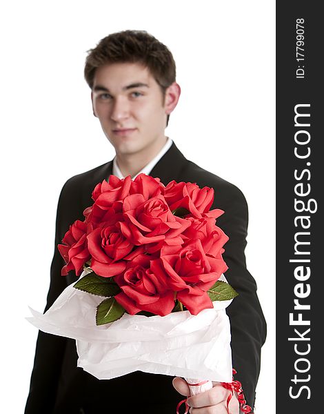 Attractive teenage boy wearing a suit holding a bouquet of fabric roses isolated on white background. Attractive teenage boy wearing a suit holding a bouquet of fabric roses isolated on white background