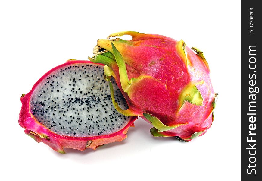 Diced dragon fruit sliced in the shell next to a whole fruit. Diced dragon fruit sliced in the shell next to a whole fruit