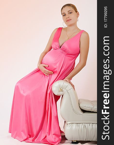 Portrait of a beautiful pregnant woman over pink background