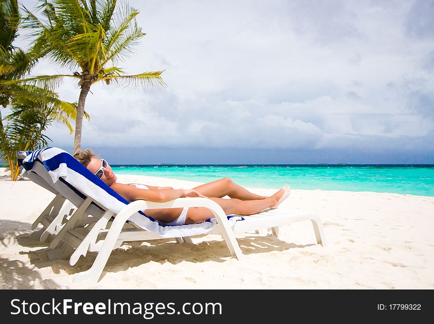 Lady relaxing in the chaise lounge on a exotic resort