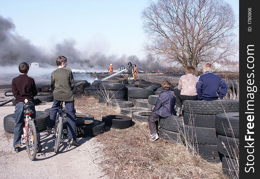 Kids observing Fireman extinguishing fire of tires in drag-strip, Panevezys Lithuania. Kids observing Fireman extinguishing fire of tires in drag-strip, Panevezys Lithuania