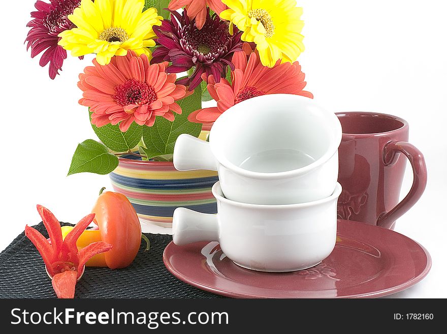 A bright bowl of festive spring flowers enhance this table set with plate,bowls ,cup,colorful peppers and a chili pepper flower. A bright bowl of festive spring flowers enhance this table set with plate,bowls ,cup,colorful peppers and a chili pepper flower.
