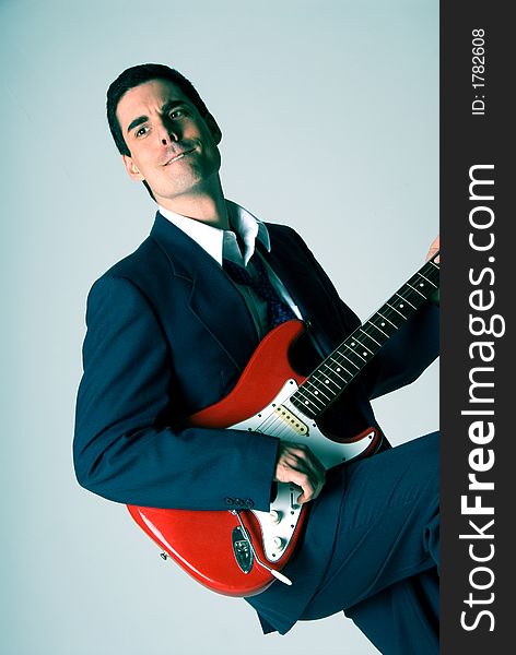 Man in blue suit with a red guitar. Man in blue suit with a red guitar