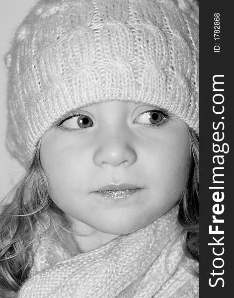 Cute girl with matching hat and scarf looking to the side in black and white. Cute girl with matching hat and scarf looking to the side in black and white