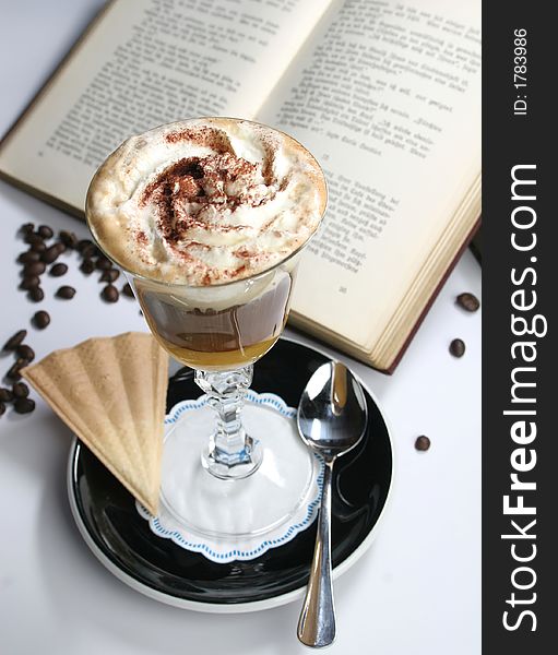 Chocholate with whipped cream in the cristal glass near the book. Chocholate with whipped cream in the cristal glass near the book