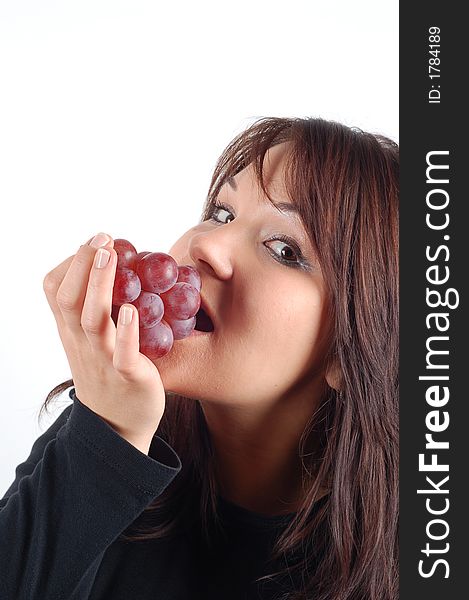 Attractive woman eating grapes on white background. Attractive woman eating grapes on white background