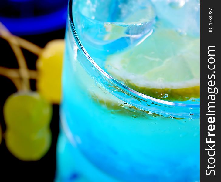 Glass of fresh drink with lemon and ice cubes