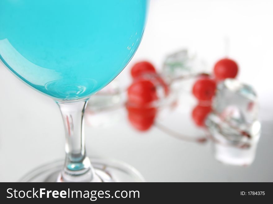 Group of four  cherries, ice cubes and blue drink. Group of four  cherries, ice cubes and blue drink