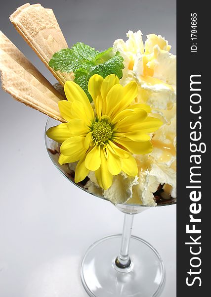 A whipped cream dessert with the yellow flower. A whipped cream dessert with the yellow flower