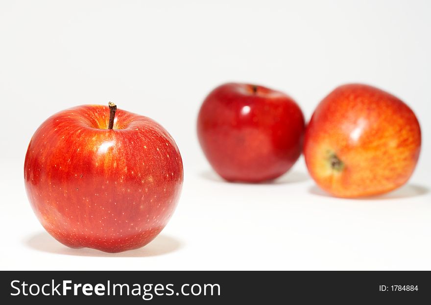 Three nice red juicy apples on white sheet. Three nice red juicy apples on white sheet