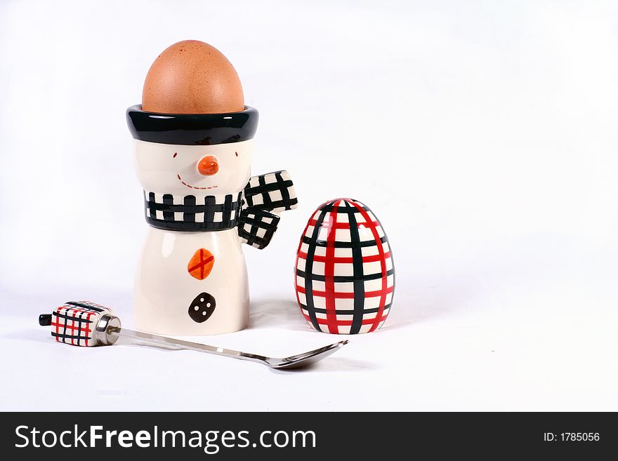 Egg in a happy egg cup with spoon and salt pot. Egg in a happy egg cup with spoon and salt pot.