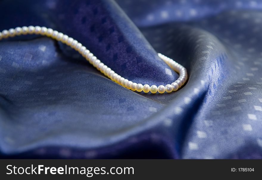Pearl necklace on dark blue silk