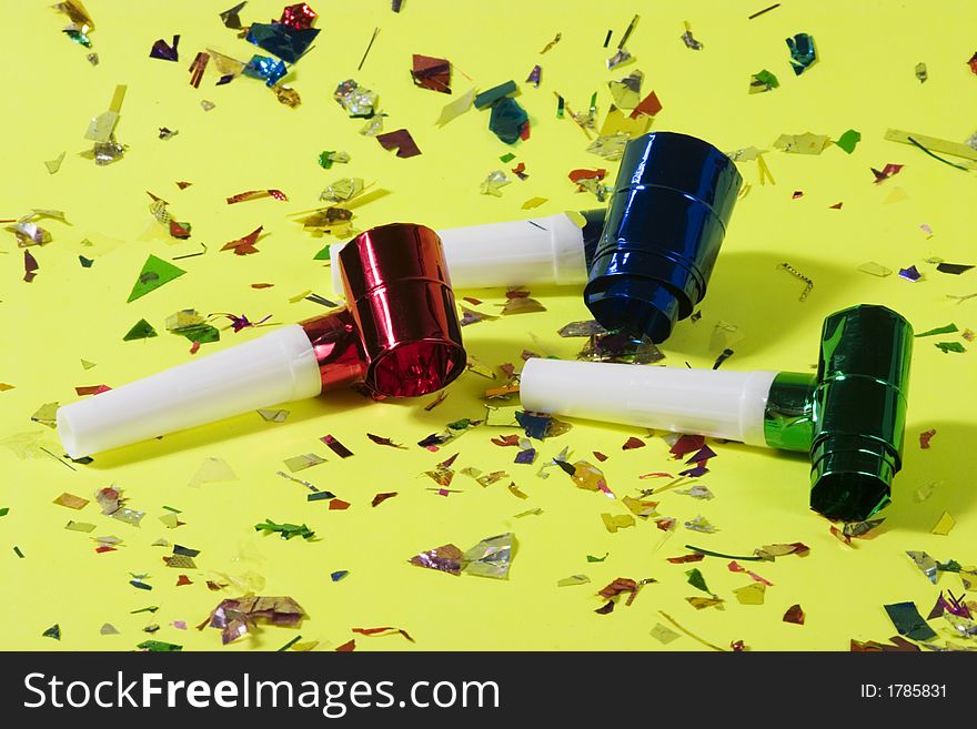 Blowers and confetti over green background. Blowers and confetti over green background